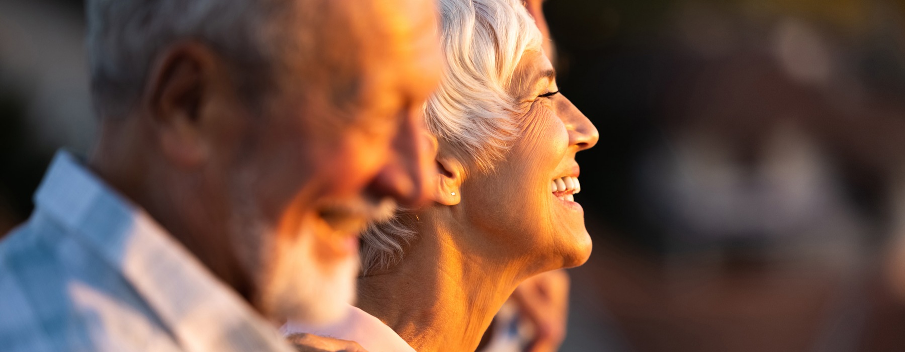 a man and woman smiling watching a sunset
